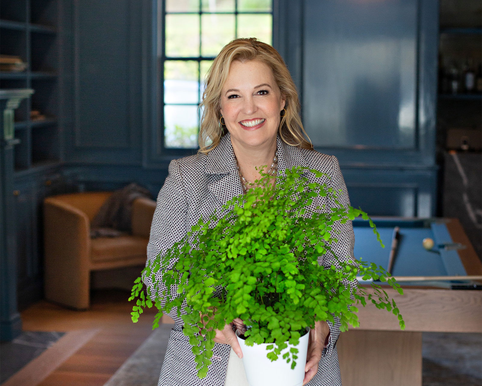 Cindi holding a fern in a house she is staging to sell